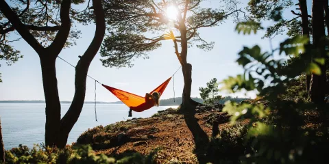 Kvinne i hengekøye ved fjorden